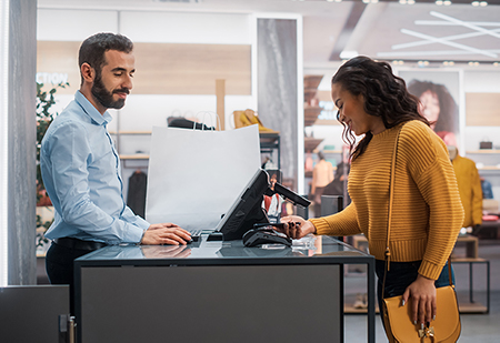 Woman paying at a store counter with her phone