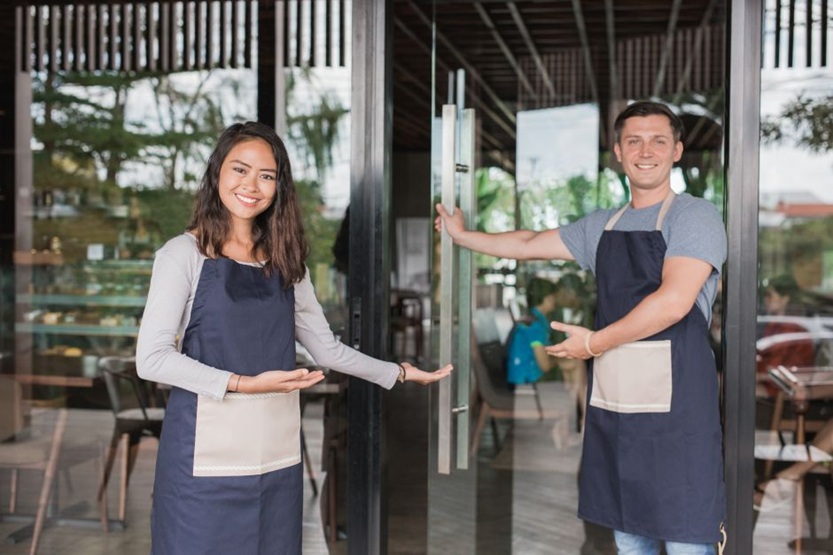 Employees at door of open business